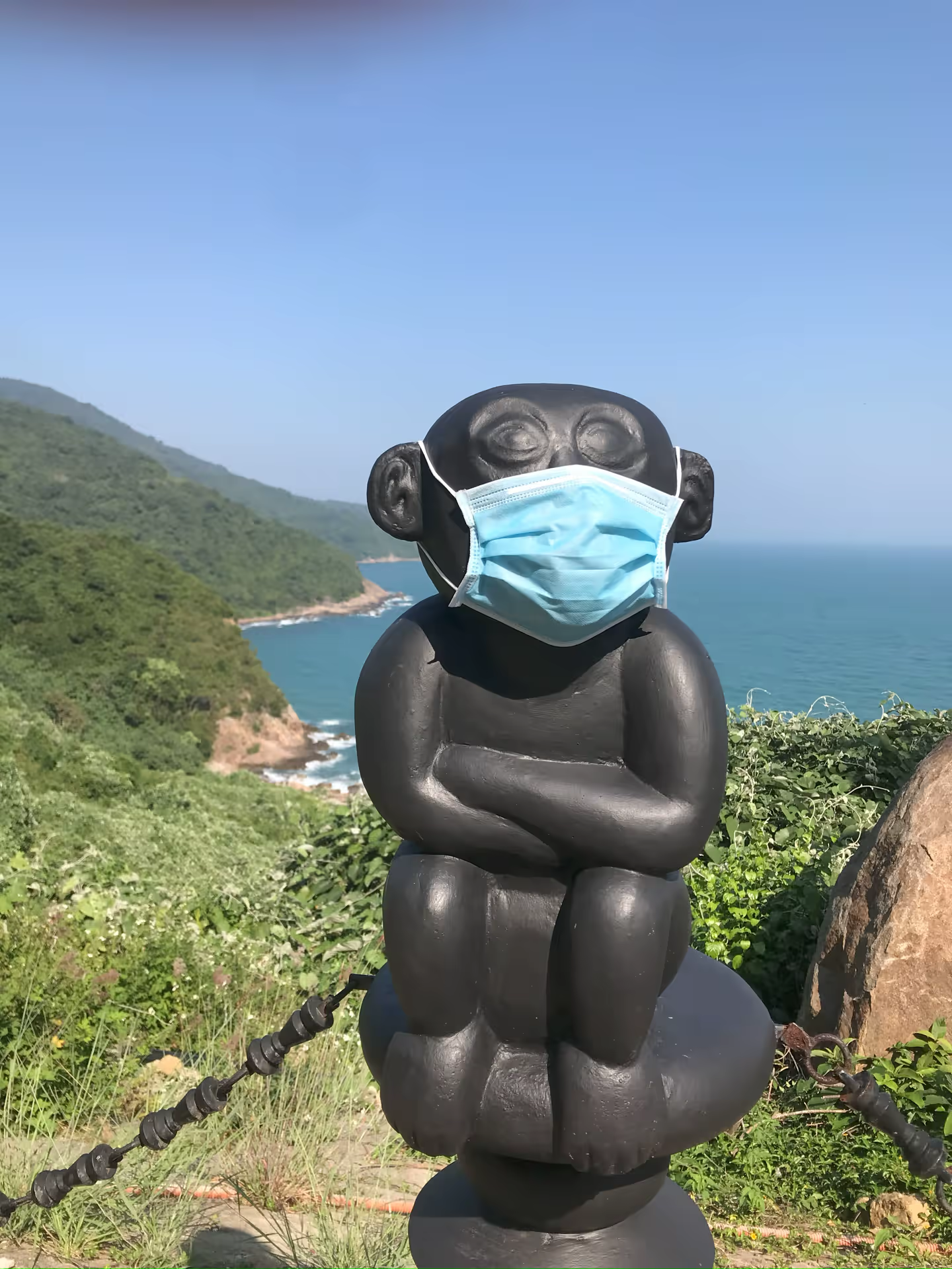 Masked monkey sculpture at the coastal viewpoint