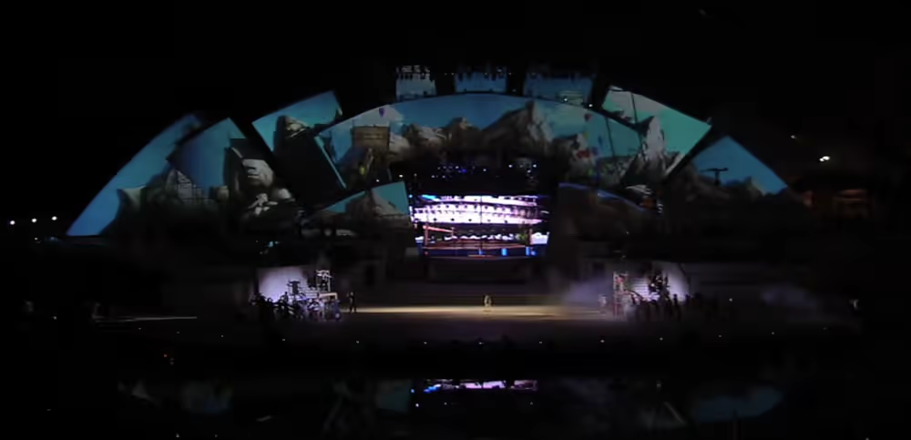 Video mapping on the curved scenography with mountain landscape and nocturnal stage action.