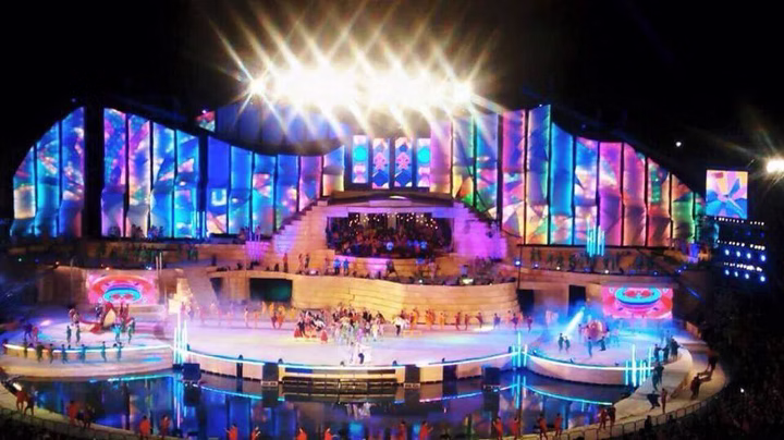Front documentation view of Vendimia 2015 with colorful scenographic lighting