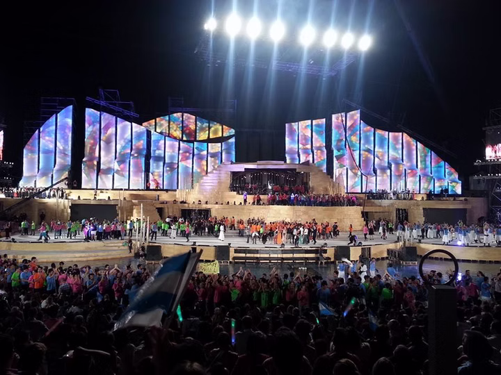 Crowd view of Vendimia 2015 with colorful stage lighting and performers